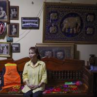 Kameay Promthep, grandmother of Duangpetch Promthep, one of the rescued Thai boys, sits next to her grandson\'s life vest during an interview at their home in the Mae Sai district of Thailand\'s northern Chiang Rai province on Friday. | AP