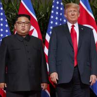 U.S. President Donald Trump stands with North Korean leader Kim Jong Un on Singapore\'s Sentosa Island on June 12. | AP