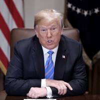 U.S. President Donald Trump speaks during a meeting at the White House in Washington on Wednesday. Trump said Wednesday that Russia isn\'t currently targeting the U.S., diverging from a public statement his own intelligence director made two days earlier. | BLOOMBERG