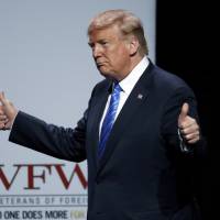 President Donald Trump acknowledges the crowd as he addresses the Veteran\'s of Foreign Wars national convention Tuesday in Kansas City, Missouri. | AP