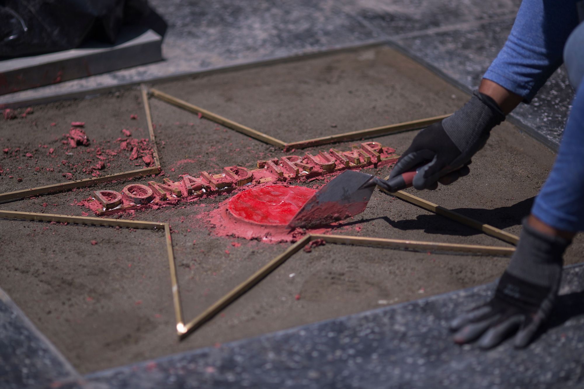Workers replace the star of U..S President Donald J. Trump on the Hollywood Walk of Fame after it was destroyed by a vandal in the early morning hours on Wednesday in Los Angeles. | AFP-JIJI