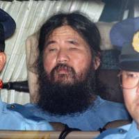 Shoko Asaharais seen in a police vehicle at the Metropolitan Police Department in September 1995, following his arrest in May the same year. | KYODO