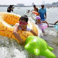 People bathe at a beach in Soma, Fukushima Prefecture, on Saturday, as the beach and another in Miyagi Prefecture opened to the public for the first time since the Great East Japan Earthquake and subsequent nuclear crisis. | KYODO