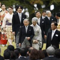 Emperor Akihito and Empress Michiko lead royal family members as they arrive at the annual autumn garden party in Tokyo in November 2014. | REUTERS