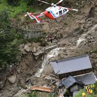 A rescue helicopter lifts up a survivor from an area hit by a mudslide in Iwakuni, Yamaguchi Prefecture, on Saturday. | KYODO