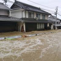 A road in the Aki district of Hiroshima city is flooded from heavy rains on Saturday morning. | KYODO