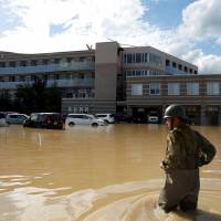 A Self-Defense Force soldier approaches Mabi Memorial Hospital for rescue work in Kurashiki, Okayama Prefecture, on Sunday. | REUTERS