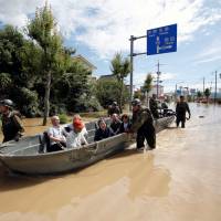Self-Defense Force soldiers rescue people from a flooded area of Kurashiki, Okayama Prefecture, on Sunday. | REUTERS