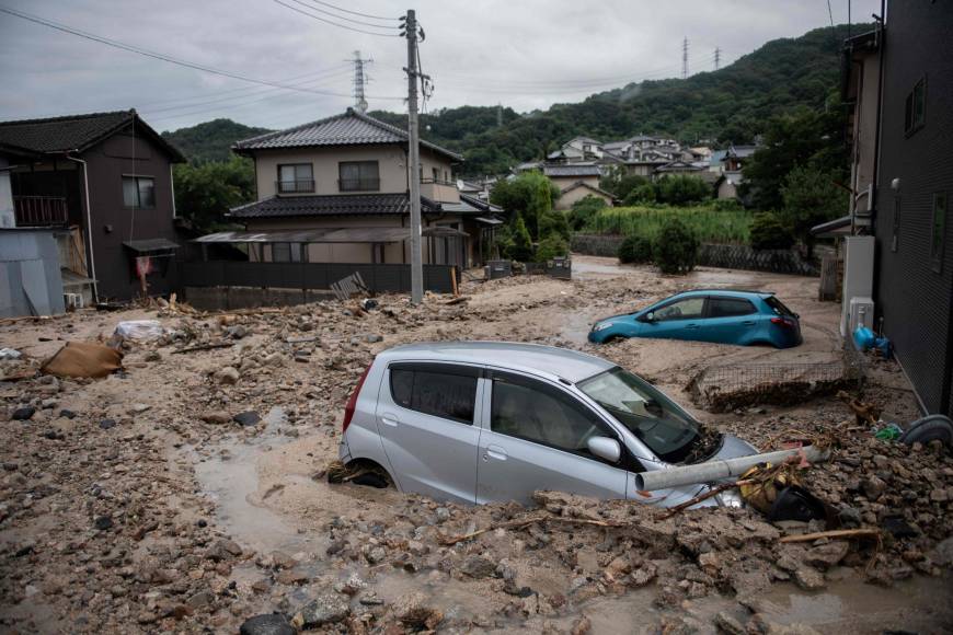 Cars are seen trapped in the mud after floods in Saka, Hiroshima Prefecture, on Sunday.