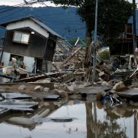 Submerged and destroyed houses are seen in a flooded area of Kurashiki, Okayama Prefecture, on Sunday. | REUTERS
