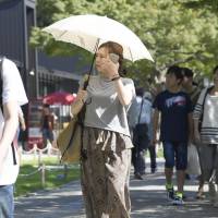 People are seen walking in Nagoya on Sunday. In many parts of the country,  when the mercury exceeded 35 C. | KYODO