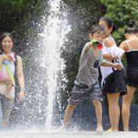 Children play in a fountain in a Nagoya park on Monday as a heat wave continued to scorch Japan. | KYODO