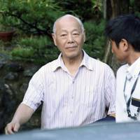 Shigetomi Hosoi, head of the Kamiyama town council in Tokushima Prefecture, leaves his house for police questioning on July 2, before being arrested on suspicion of bribery. | KYDOO