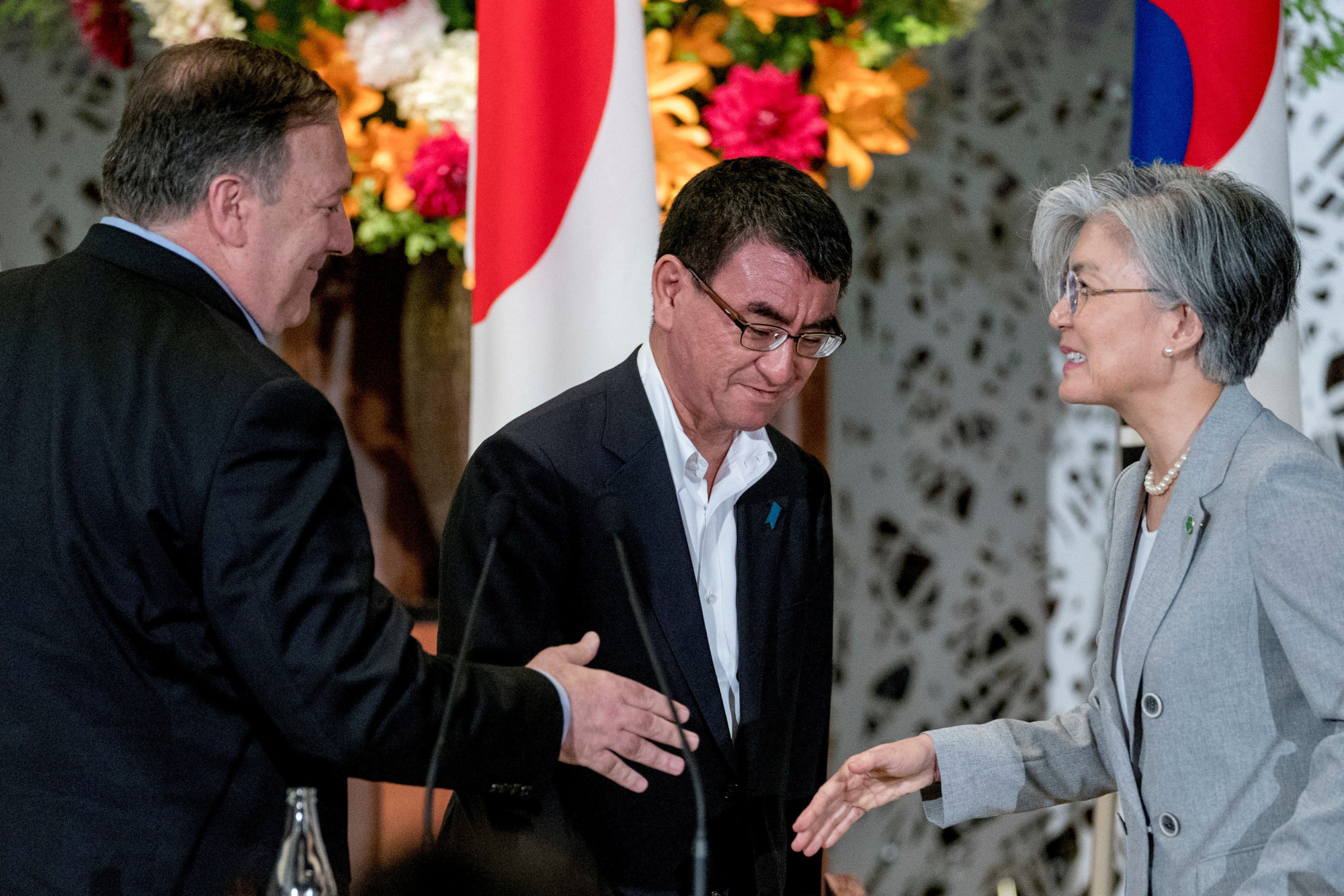 U.S. Secretary of State Mike Pompeo, Foreign Minister Taro Kono and South Korean Foreign Minister Kang Kyung-wha shake hands after their joint news conference in Tokyo on Sunday. | POOL / VIA REUTERS