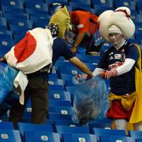 Japan supporters collect garbage after the 2018 World Cup round of 16 soccer match between Belgium and Japan at the Rostov Arena in Rostov-On-Don, Russia, on Monday. | AFP-JIJI