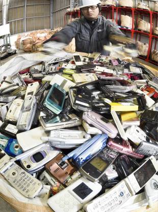 A man sorts through discarded mobile phones in Kitakyushu.