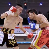 Ryuya Yamanaka (left) fights against Vic Saludar of the Philippines in their WBO minimumweight title bout on Friday in Kobe. | AFP-JIJI