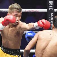 Sho Kimura punches challenger Froilan Saludar in the first round of Friday\'s WBO flyweight title fight in Qingdao, China. Kimura retained his title with a sixth-round knockout. | KYODO