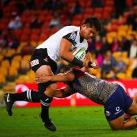 The Sunwolves\' Kazuki Himeno is tackled by the Reds\' Alex Mafi in Super Rugby action on Friday night in Brisbane, Australia. | AFP-JIJI