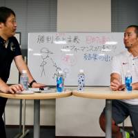 Nippon Sport Science professor Masamitsu Ito (left) and Stanford football assistant coach Tsuyoshi Kawata discuss some of the issues that arise in  coaching in both Japan and the United States during a workshop on Friday in Tokyo. | KAZ NAGATSUKA