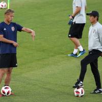 Japan manager Akira Nishino (right) speaks with Keisuke Honda during a training session on Sunday in Rostov-on-Don, Russia. | REUTERS