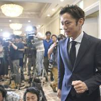 Daisuke Takahashi walks past reporters at a news conference to announce his return to competitive figure skating on Sunday. | KYODO