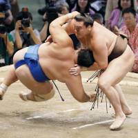 Hakuho outmuscles Kotoshogiku on Tuesday at the Nagoya Sumo Tournament. | KYODO