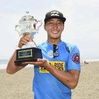 Teenager Jo Azuchi poses with the trophy after winning the Shonan Open surfing competition on Wednesday in Fujisawa, Kanagawa Prefecture. | KYODO