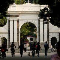 People walk near the gate of Tsinghua University in Beijing in 2016. | REUTERS