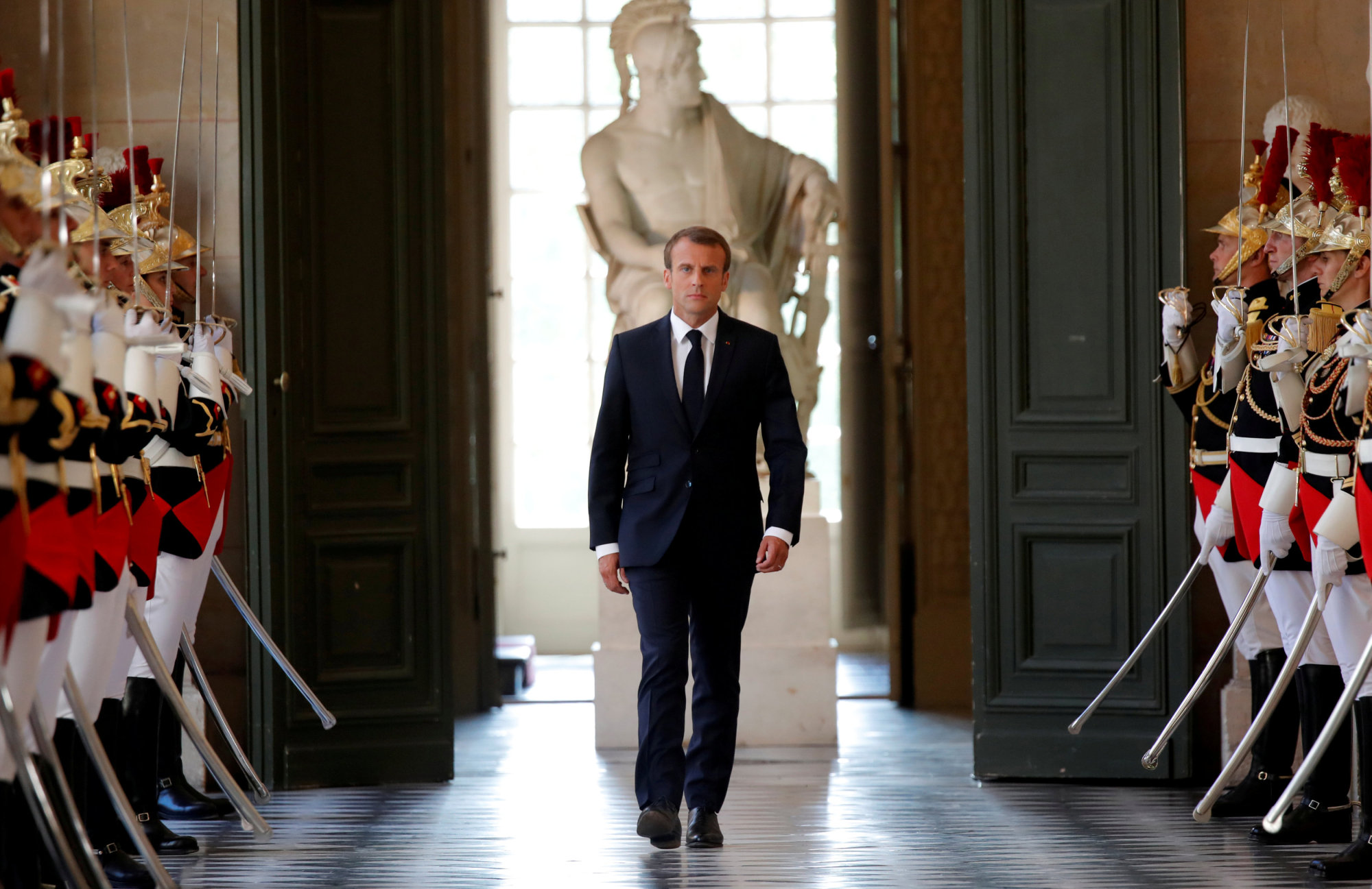French President Emmanuel Macron walks through the Galerie des Bustes (Busts Gallery) to access the Versailles Palace's hemicycle to address both the upper and lower houses of the French parliament (National Assembly and Senate) at a special session in Versailles near Paris July 9. | REUTERS