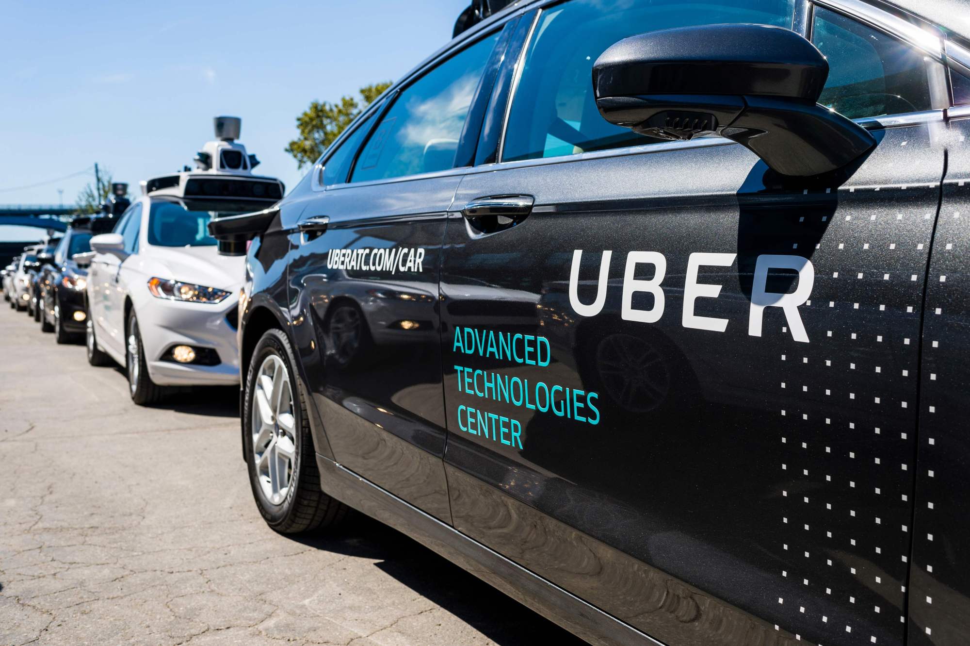 Pilot models of the Uber self-driving car are displayed at the Uber Advanced Technologies Center in Pittsburgh, Pennsylvania in September 2016. Toyota will pump about &#36;500 million into the ride-hailing giant as part of a deal to work together on mass-producing self-driving vehicles, the carmaker said Tuesday. | AFP-JIJI