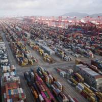 Containers are stacked at a port in Shanghai. China says it is prepared for a protracted trade war with the U.S. | BLOOMBERG