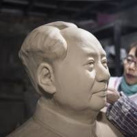 A worker sculpts a bust of former Chinese leader Mao Zedong inside a workshop at the Jingdezhen Porcelain Factory in Jingdezhen in China\'s Jiangxi province in January. | BLOOMBERG