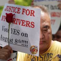 The New York Taxi Workers Alliance holds a vigil outside City Hall in New York Tuesday in support of for-hire-vehicle cap. New York\'s city council on Wednesday dealt a blow to Uber and other car-for-hire companies, passing a bill to cap the number of vehicles they operate and impose minimum pay standards on drivers. | TIMOTHY A. CLARY / VIA AFP