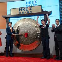 Xiaomi Corp. officials hold a ceremony on July 9 at the Hong Kong Stock Exchange to mark its listing on the bourse. | BLOOMBERG