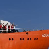 Crew members wave as the rescue ship Aquarius, chartered by French aid group SOS Mediterranee and Doctors Without Borders (MSF), leaves the harbor of Marseille, southeastern France, on Aug. 1 after having been docked for a month for maintenance work. | AFP-JIJI