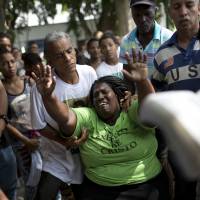 Wania de Moraes grieves for her murdered 13-year-old son, Jeremias Moraes da Silva, during his burial service in Rio de Janeiro on Feb. 8. | AP