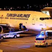 A fireman is seen entering the cargo compartment of a Turkish Airlines flight parked on the tarmac of Budapest Airport Wednesday after one terminal of the airport and its surroundings were briefly shut down as the Disaster Management Authority ordered an investigation due to an overheated container carrying an isotope on an incoming flight. Neither the airport nor the disaster control authority confirmed that the flight affected was operated by Turkish Airlines. | REUTERS