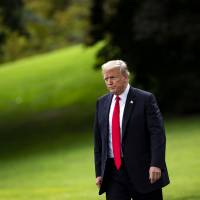 U.S. President Donald Trump walks on the South Lawn of the White House before boarding Marine One in Washington on Tuesday. | BLOOMBERG
