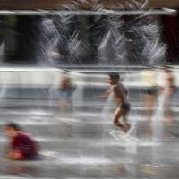 Children play at a fountain in Milan, Italy, Thursday. Hot air from Africa is bringing a new heatwave to Europe, prompting health warnings about Sahara Desert dust and exceptionally high temperatures that are forecast to peak at 47 degrees Celsius (116.6 Fahrenheit) in some southern areas. | AP