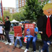Protesters hold their banners in front of the Alexandria Federal Court in Alexandria, Virginia, Tuesday on day one of Paul Manafort\'s trial. | AP