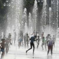 People cool off in a water fountain in Nice on Tuesday amid a heat wave sweeping across northern Europe. | AFP-JIJI