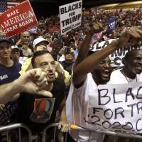 Supporters of President Donald Trump shout down a CNN news crew before a rally in Tampa, Florida, Tuesday. Amid the \"Trump 2020\" placards, the \"Women for Trump\" signs and the \"CNN SUCKS\" T-shirts, the most inscrutable message that came out of Donald Trump\'s Tampa rally on Tuesday evening was a letter, Q. | AP