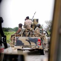 A Nigerian army convoy vehicle drives ahead with an anti-aircraft gun, on its way to Bama, Borno State, Nigeria, in 2016. Picture taken from inside a vehicle. | REUTERS