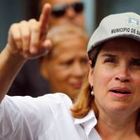 The Mayor of San Juan, Carmen Yulin Cruz, points as she visits the Playita community with U.S. Sen. Bernie Sanders in San Juan last October. U.S. President Donald Trump\'s administration killed Puerto Ricans through \"neglect,\" the mayor of the island\'s capital, Yulin Cruz, said on Wednesday a day after the official death toll for Hurricane Maria was raised to nearly 3,000. | RICARDO ARDUENGO / VIA AFP-JIJI