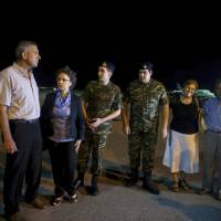 Greek soldiers Aggelos Mitretodis (third left) and Dimitros Kouklatzis (third right) are welcomed by their parents after their arrival early Wednesday at an airport in the northern city of Thessaloniki, after spending months in a Turkish prison. | AP