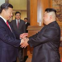 Chinese President Xi Jinping shakes hands with North Korean leader Kim Jong Un in Beijing in this undated photo released June 20. | KCNA / VIA REUTERS