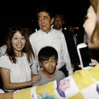 Prime Minister Shinzo Abe poses with participants at a summer festival in Nagato, Yamaguchi Prefecture, on Saturday. He was visiting his constituency to lobby rank-and-file members of his ruling Liberal Democratic Party ahead of the party\'s presidential race next month, which could turn him into Japan\'s longest-serving prime minister. | KYODO