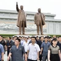 North Korean citizens visit Mansu Hill in Pyongyang in July where bronze statues of late leaders Kim Il Sung and Kim Jong Il have been erected. | KYODO