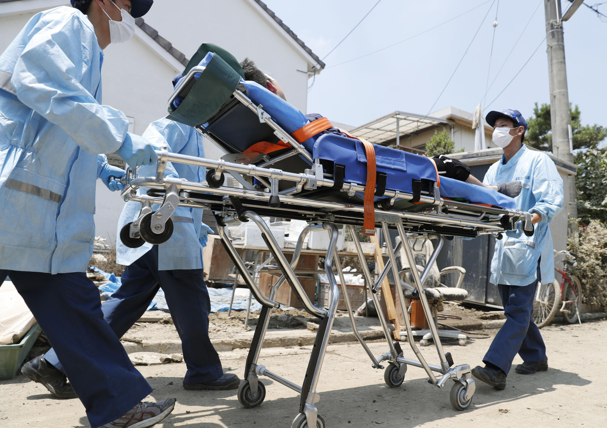 A person suspected of suffering from a heat-related illness is transported to an ambulance in Kurashiki, Okayama Prefecture, in July. | KYODO